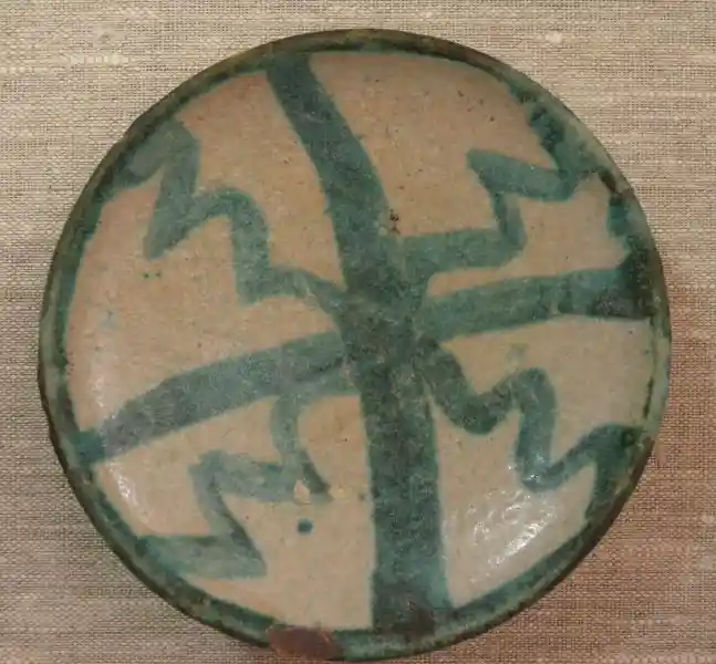 Four-point cross design on a clay plate intersected with wavy cross